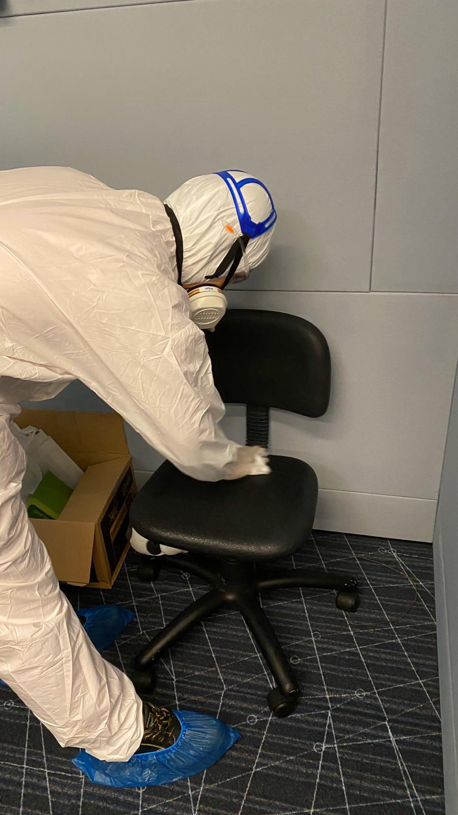 Technician applying surface coating to a handrail in a care facility corridor