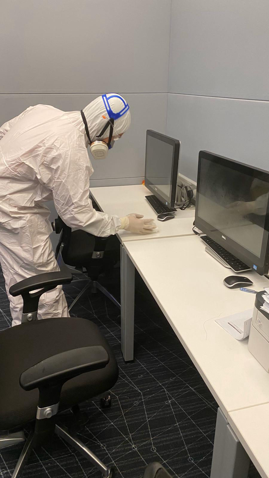 Technician applying antimicrobial surface coating in a newly built commercial interior